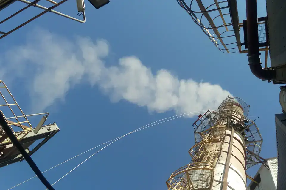 Chimenea industrial con pluma de emisión, fuente fija declarada en RETC